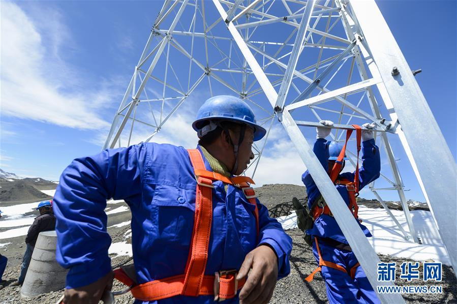电力施工作业人员在高空组立后峡35千伏输电线路工程24号杆塔。