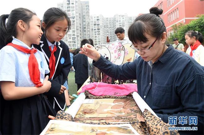 5月28日，在沙坪坝区西永第一小学校，手工艺人在展示传统蜀绣。