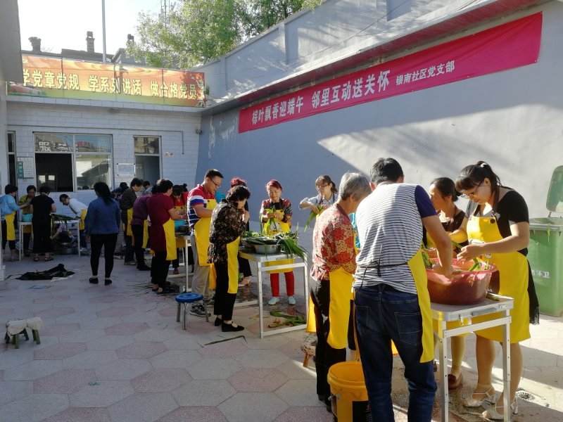 米脂县银南社区举行以“粽叶飘香迎端午，邻里互动送关怀”为主题的包粽子比赛。