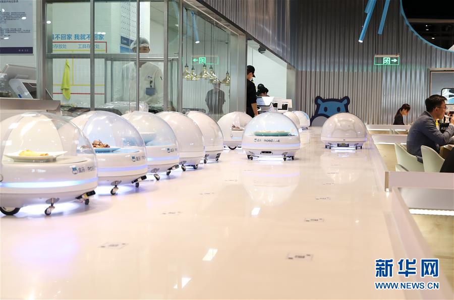 10月15日，装载菜品的送餐机器人按照系统规划路线排队出发。新华社记者 方喆 摄