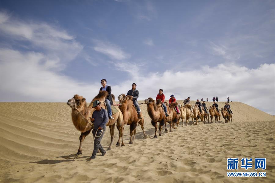 10月16日，游客在罗布人村寨里骑着骆驼游览。新华社记者 赵戈 摄