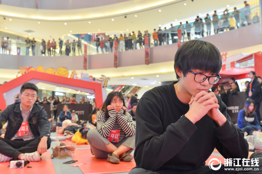 11月11日，以 “谁是呆呆王”为主题的发呆比赛在杭州滨江宝龙城举行。百余名市民报名参赛，选手们站着、躺着、趴着“各显神通”。  　　据悉，主办方旨在通过这项活动，让平日里紧张忙碌的人们能够在生活中静下心来，发个呆，忘掉烦恼琐事，舒缓焦虑情绪。（浙江在线记者 于诗奇 奕婷婷 摄）
