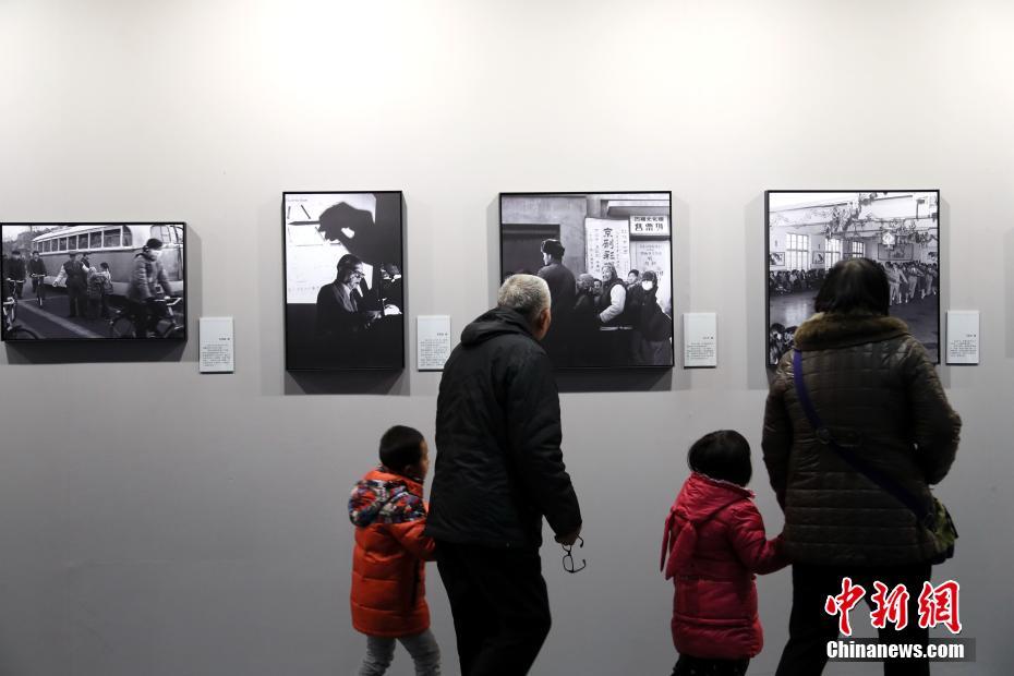 11月20日，河南三门峡，观众参观“影像见证四十年”摄影展。本次展览以摄影的视角再现民众生活、教育、卫生等各方面翻天覆地的变化，集中彰显中国改革开放40年取得的伟大成就。中新社记者 王中举 摄