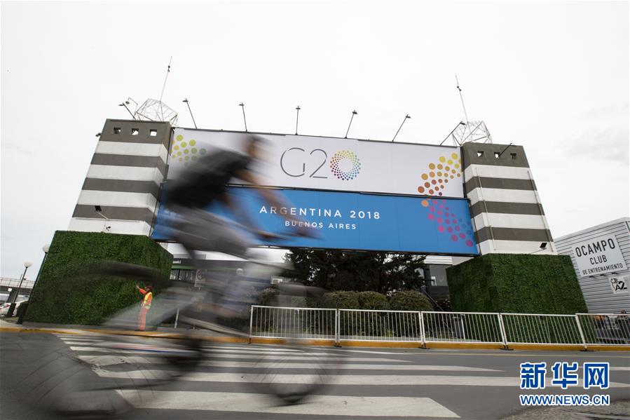 11月27日，在阿根廷首都布宜诺斯艾利斯，一名市民骑车经过G20峰会会场——科斯塔·萨尔格罗会展中心。二十国集团（G20）领导人第十三次峰会将于11月30日至12月1日在布宜诺斯艾利斯举行。新华社记者 李明 摄