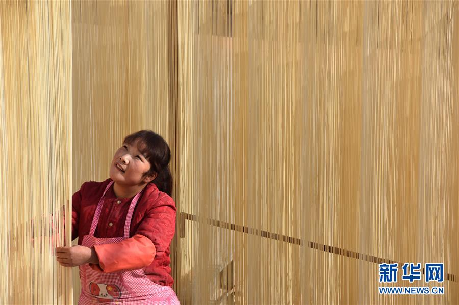 11月28日，村民程彩宁在自家门口晾晒制作好的手工挂面。　新华社记者都红刚摄