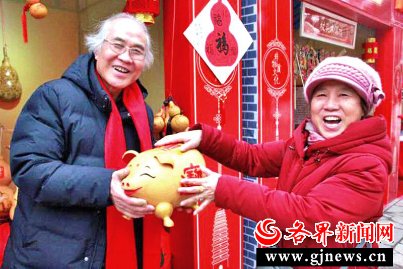 关中葫芦非遗传承人梁平安（左）与游客展示葫芦福猪