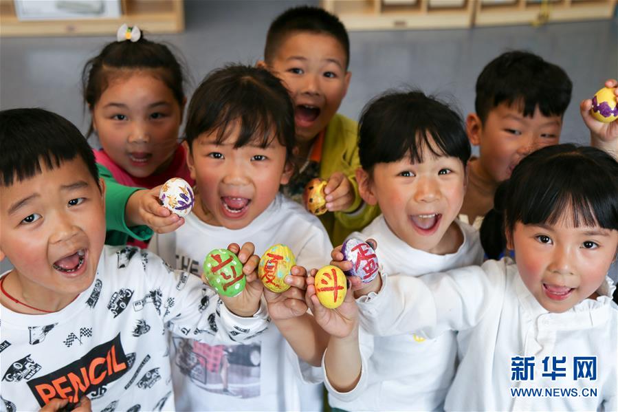 　5月5日，浙江省湖州市长兴县张家村花园幼儿园的小朋友展示手绘彩蛋。 立夏节气将至，人们参加绘彩蛋、称体重等活动，体验传统民俗。 新华社发（许斌华 摄）