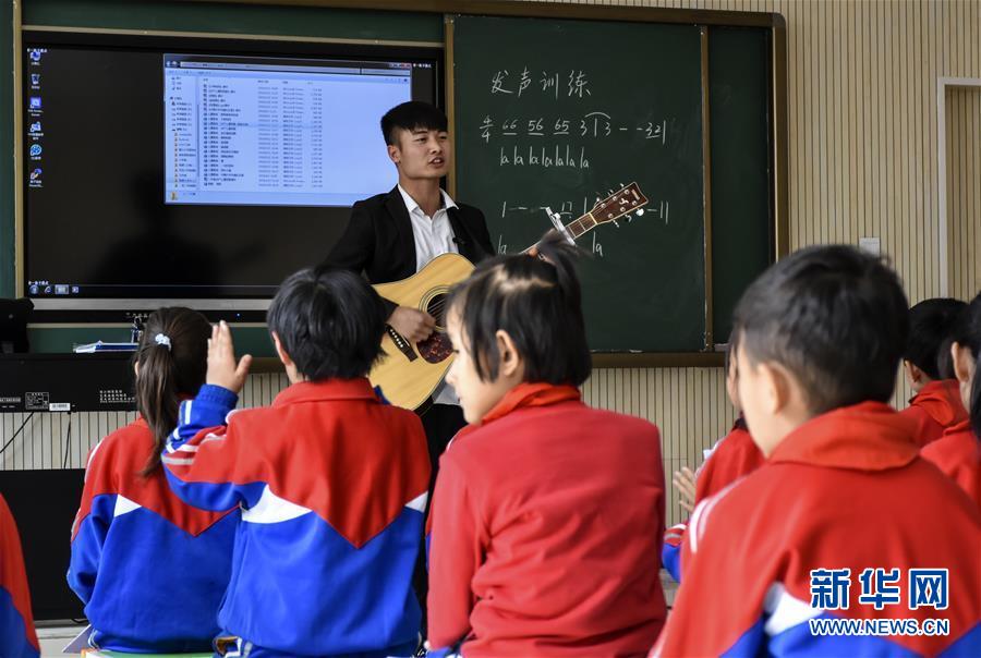 在新疆且末县第二小学，史兴林在给学生上音乐课（3月15日摄）。新华社记者 周晔 摄