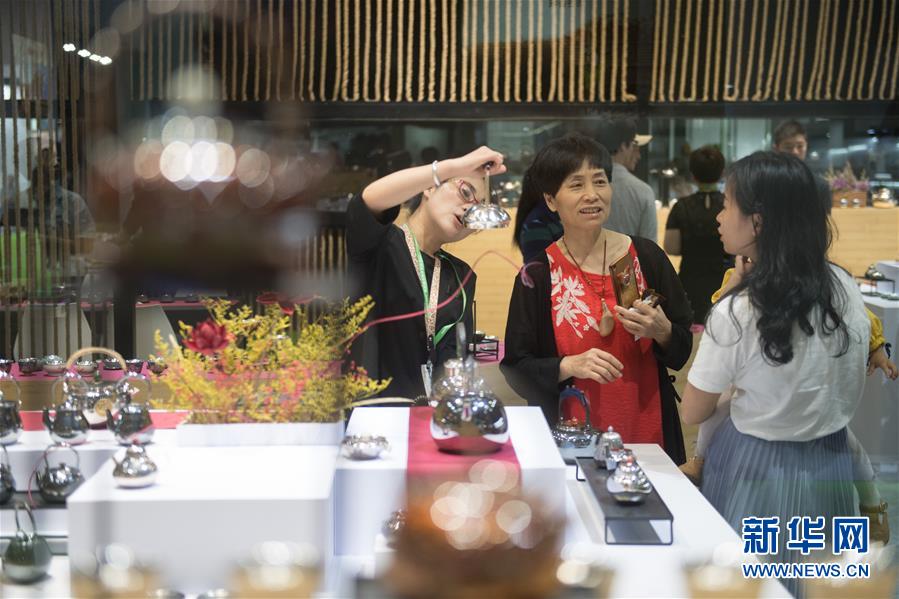 5月15日，参观者在一家展商的展台选购茶壶。 当日，第三届中国国际茶叶博览会在浙江杭州开展。本届国际茶博会展示展销总面积7万平方米，吸引国内外参展商总计1500余家。 新华社记者 翁忻旸 摄
