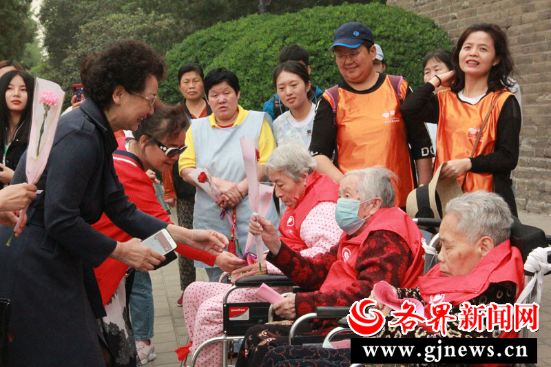 志愿者向出游的老人赠送鲜花