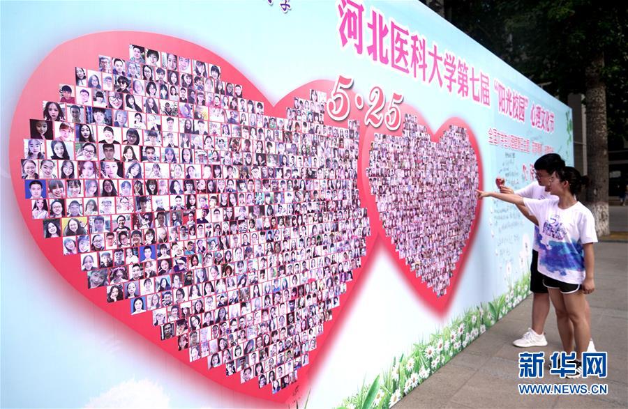 5月23日，大学生在“阳光笑脸墙”前拍照。 当日，为迎接“5·25”全国大学生心理健康日，河北医科大学举办第七届“阳光校园”心理文化节活动。 新华社记者 王晓 摄