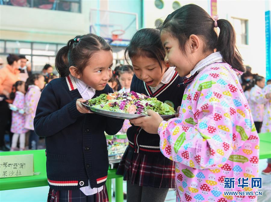 5月29日，孩子们欣赏自己制作的沙拉。 当日，西藏自治区实验幼儿园大班的小朋友们在家长和老师的帮助下，一起制作午饭，共同迎接即将到来的“六一”儿童节。 新华社记者 晋美多吉 摄