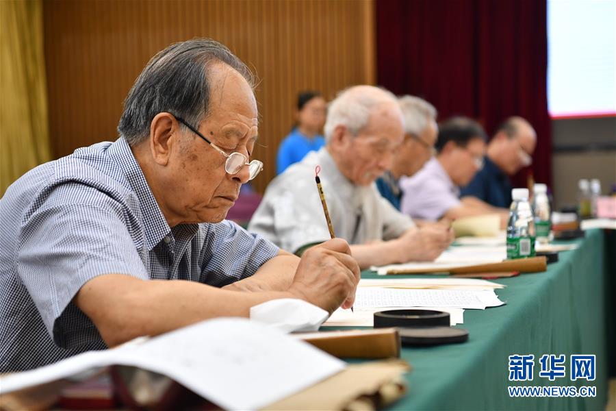 7月16日，陕西师范大学退休教师耿征（左一）在书写录取通知书。　新华社记者 张博文 摄