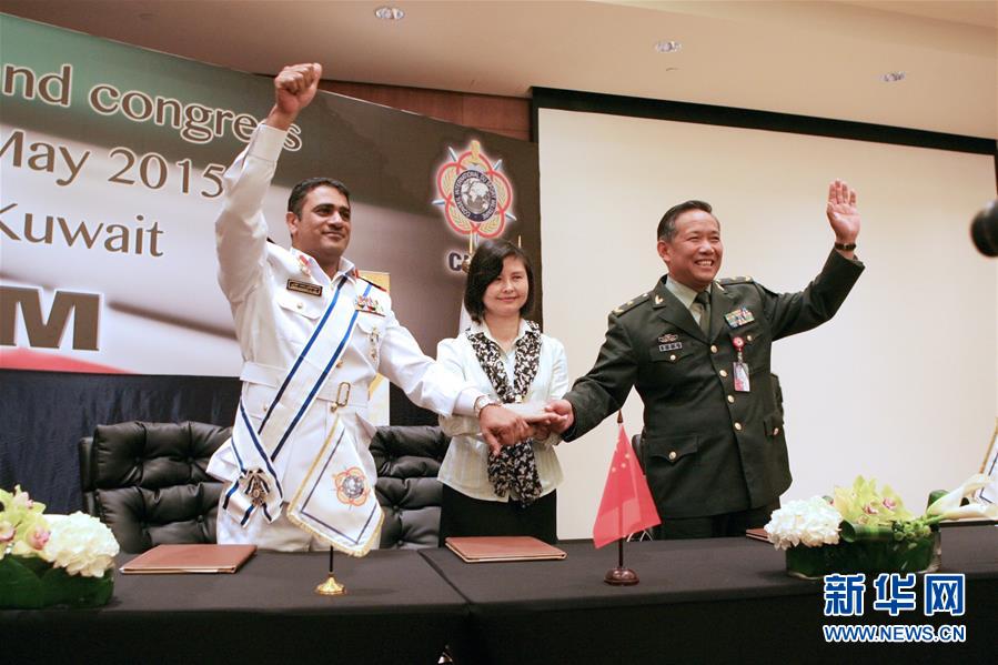 2015年5月21日，国际军体主席哈基姆·艾尔希诺（左）向中国人民解放军代表团团长马开平（右）和中国武汉市副市长刘英姿（中）表示祝贺。当日，在科威特首都科威特城召开的国际军事体育理事会第70届代表大会第四次全体会上，国际军体主席哈基姆·艾尔希诺正式宣布，中国武汉获得2019年第七届世界军人运动会承办权。新华社记者 李志平 摄