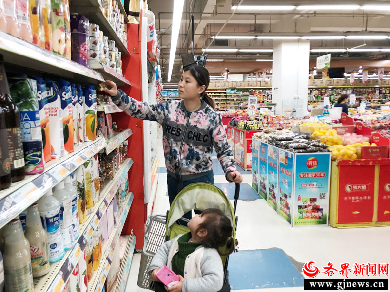 在西安市文艺路华润万家超市进 口食品区，顾客正在 挑选商品。