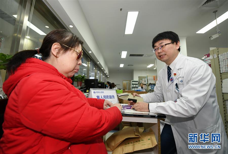 1月2日，陕西省人民医院临床药师郭振军（右）为盲人患者柴新新介绍如何用药。　新华社记者 李一博 摄