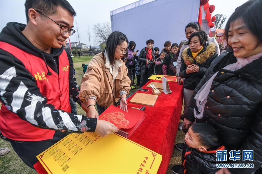 1月5日，工作人员在游园会活动现场为群众印制分发新春年历。 当日，浙江省杭州市余杭区塘栖村举办迎新春“幸福游园会”，内容包括重现不同年代结婚场景、庆丰收甘蔗运动会、传统美食制作、趣味游戏等，让当地百姓在幸福欢乐的气氛中迎接即将到来的新春佳节，同时也感受家乡发展带来的新变化。 新华社记者 徐昱 摄