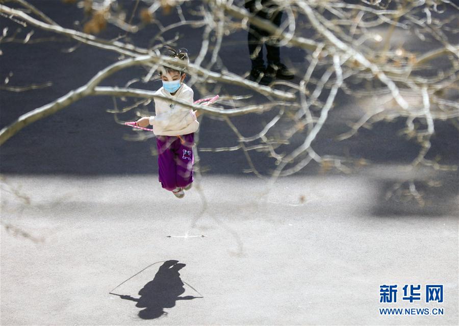 春天来临，天气转暖，随着疫情防控形势向好，北京市西城区香炉营东巷某小区的居民纷纷走出家门，以各种方式锻炼身体，强健体魄，享受春光。 这是一个女孩在树下跳绳（3月15日摄）。 新华社记者兰红光摄