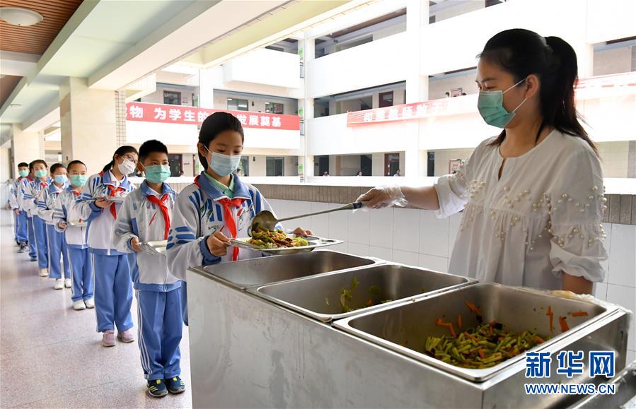 4月27日，陕西师范大学锦园小学的学生在排队领取午餐。新华社记者 刘潇 摄