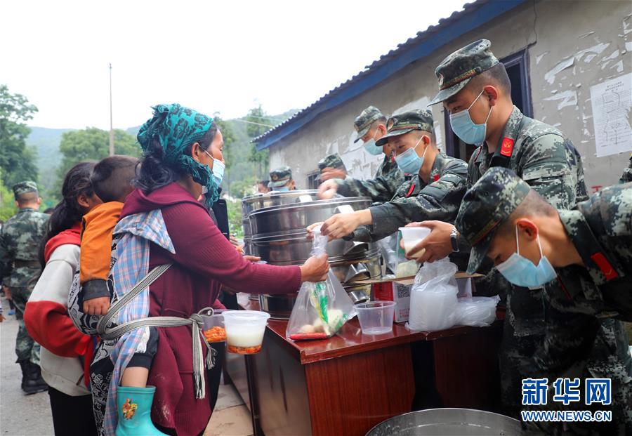 6月29日，武警四川总队凉山支队官兵在冕宁县大马乌村安置点为群众发放早餐。 新华社发（李结义 摄）