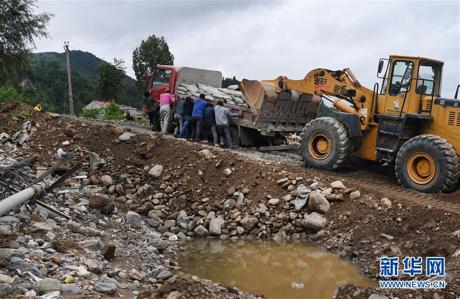 8月23日，洛南县城关街道刘湾村的受灾群众在参与村组道路的抢修。
