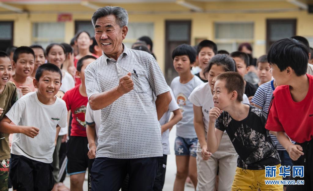 马维帅（前）教孩子们跳“陕北秧歌”（8月6日摄）。